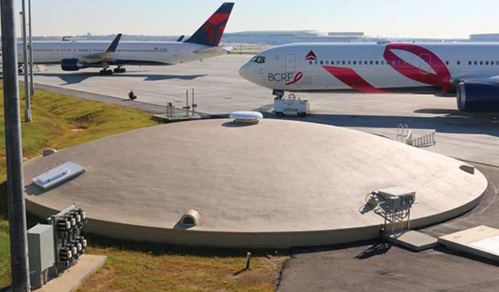 CROM prestressed concrete deicing fluid management tank at an airport near commercial airplanes.